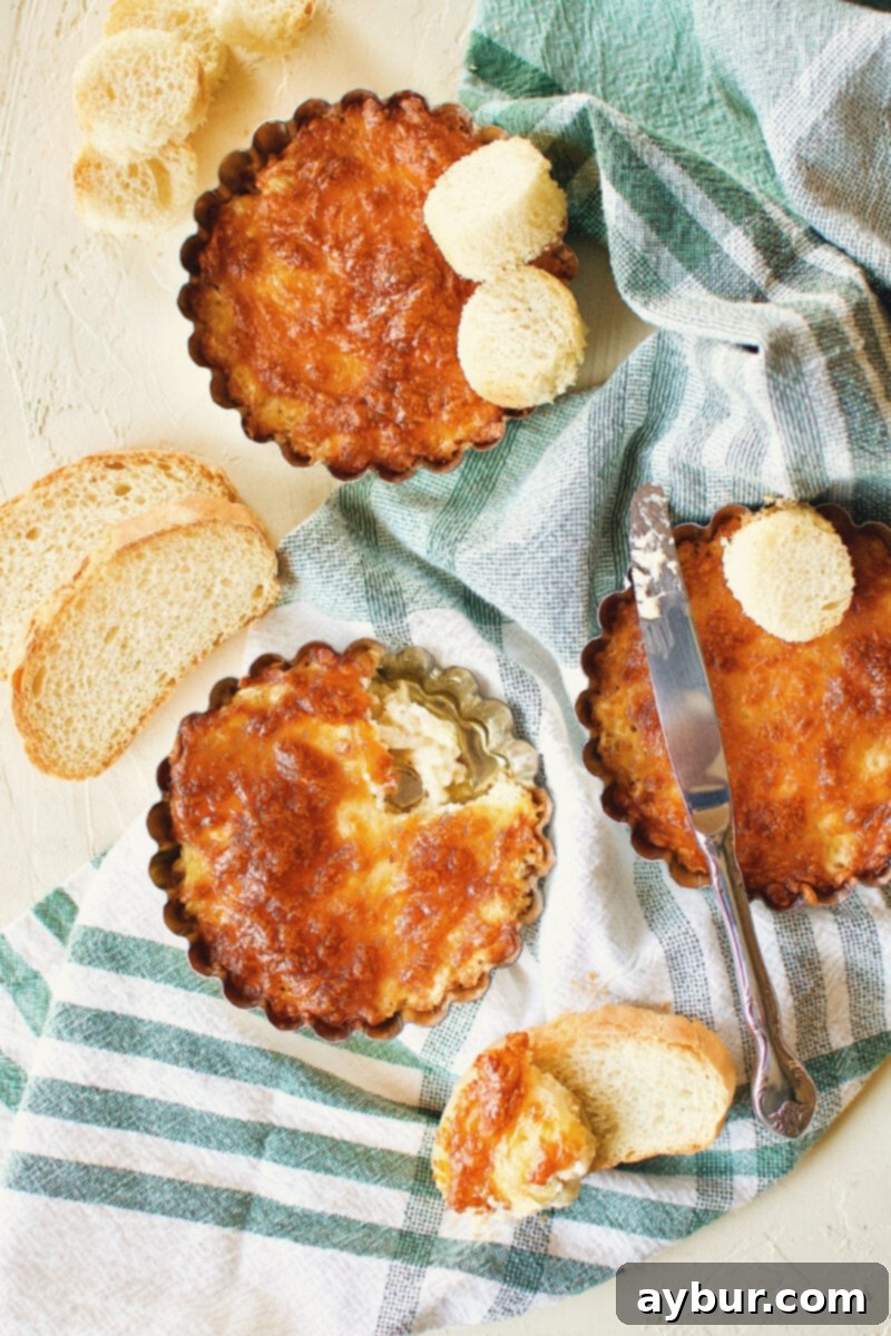 A small bowl of Artichoke Three Cheese Dip with a serving scooped onto a piece of toast.