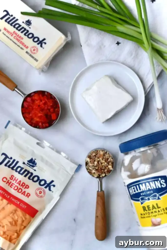 High-quality ingredients for a homemade 1919 Pimento Cheese recipe, adapted from Joanna Gaines' Magnolia Table Cookbook, featuring cheddar cheeses, cream cheese, pimentos, and pecans.