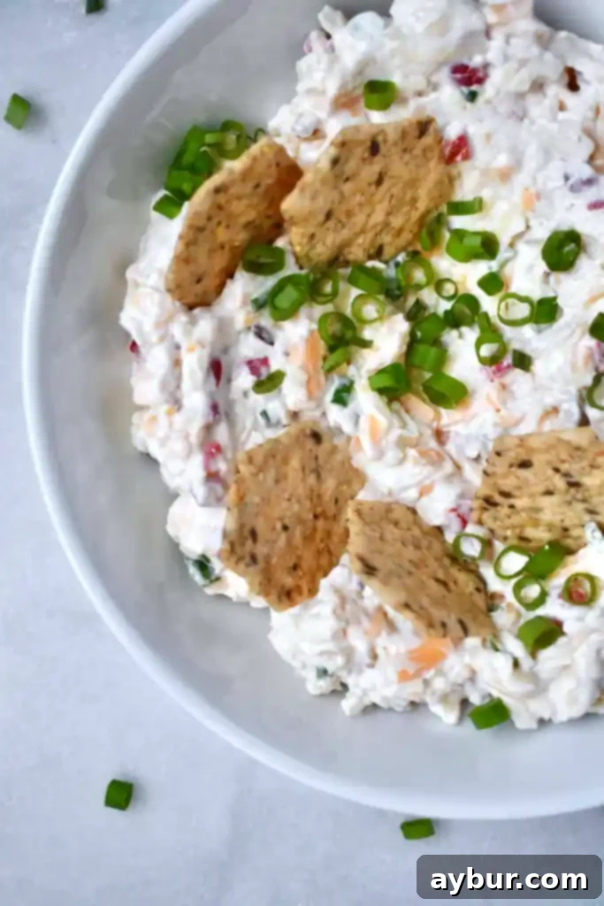A bowl of creamy, homemade Pimento Cheese with a serving spoon, adapted from Joanna Gaines' original recipe.