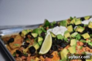 Perfect Movie Night Sheet Pan Nachos 2 Close-up of crispy tortilla chips topped with melted cheese and savory ground meat