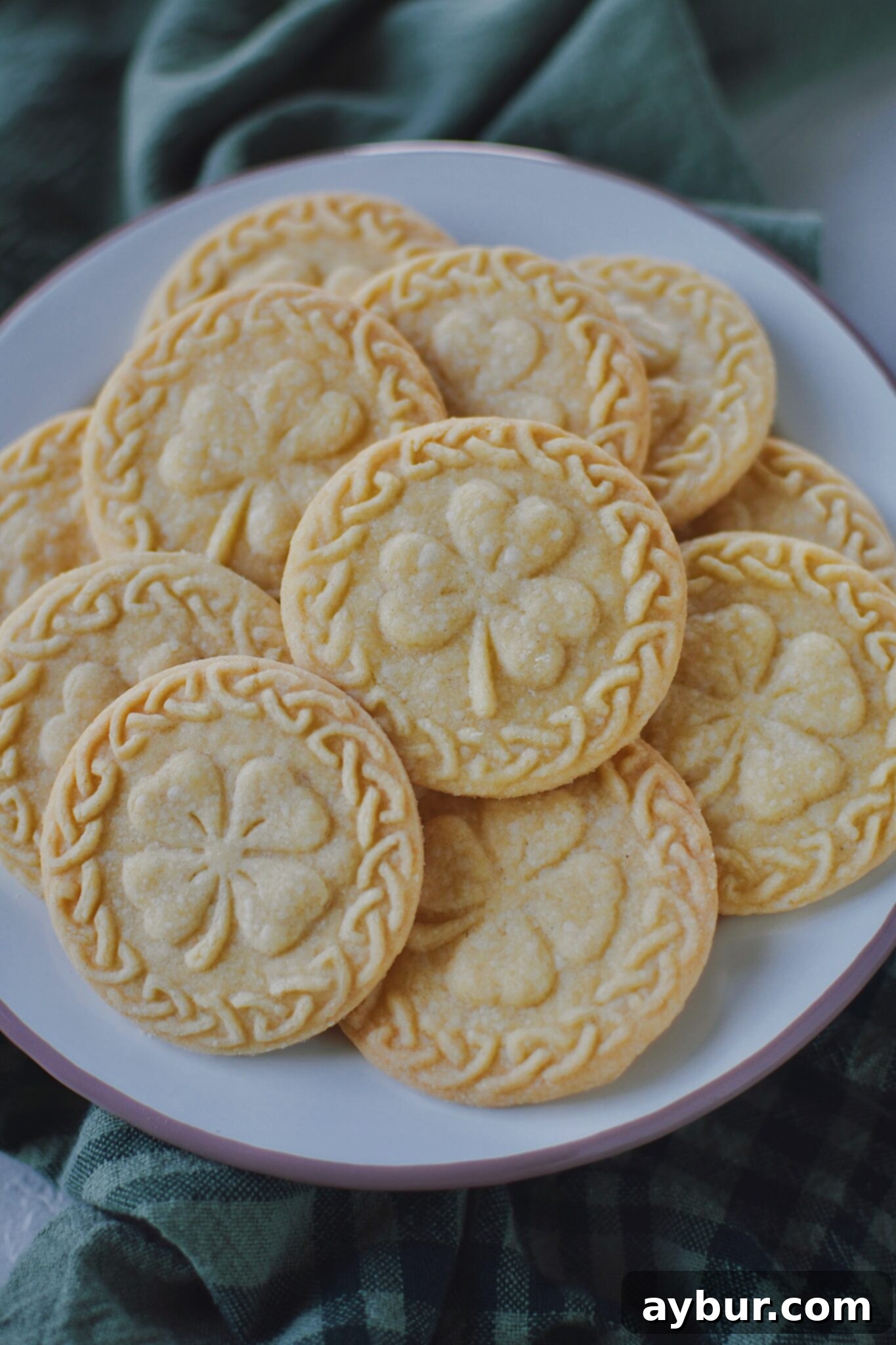 Baked shortbread piled up on a plate ready to be enjoyed with a cup of tea.