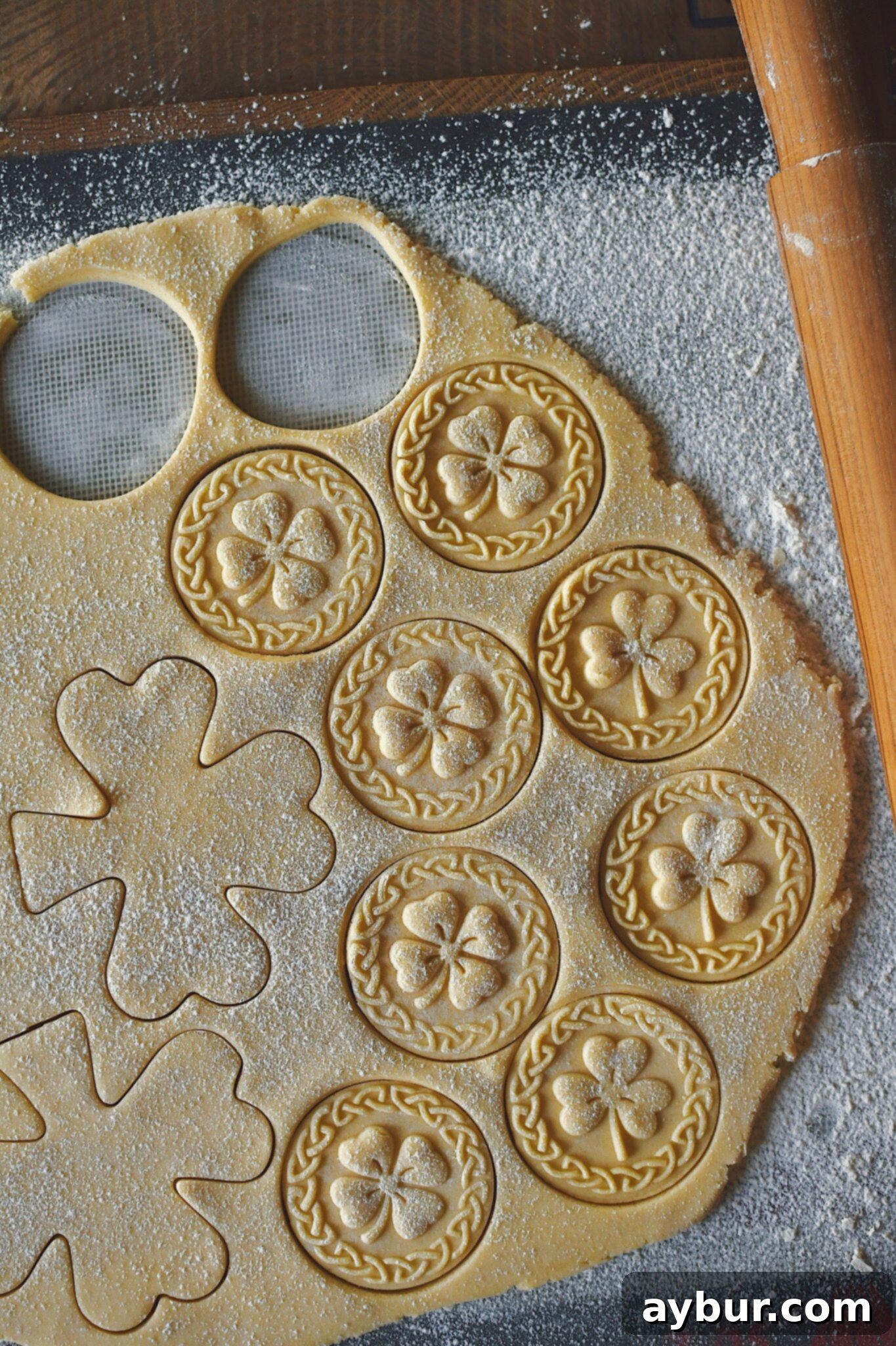 Rolling out the shortbread dough, stamping, and cutting the cookies.
