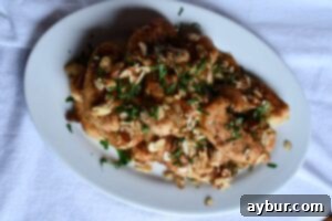 Golden brown almond crusted chicken tenderloins on a serving plate, fresh from the pan.