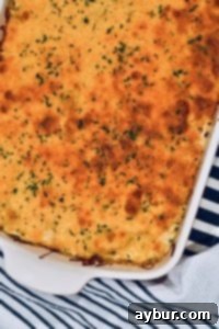 The Quintessential Comfort Casserole 2 Close-up of a casserole's interior, showing creamy sauce, discernible pieces of artichoke, and the unique texture of water chestnuts.
