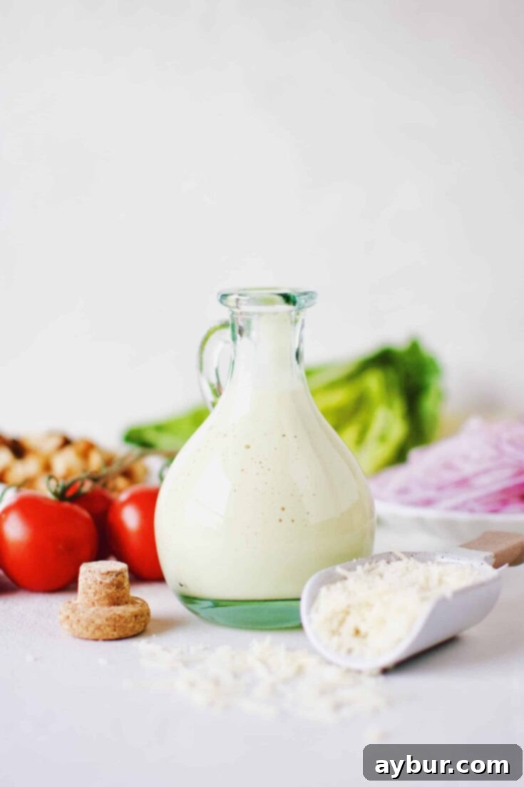 Velvety Caesar Dressing 6 Creamy Caesar Dressing in a bottle surrounded by ingredients needed to make a Caesar Salad.