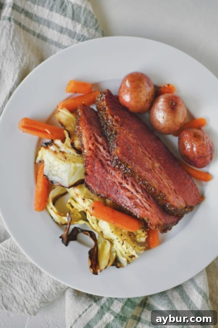 A plate featuring perfectly cooked corned beef and cabbage, surrounded by tender potatoes and carrots, ready to be enjoyed.