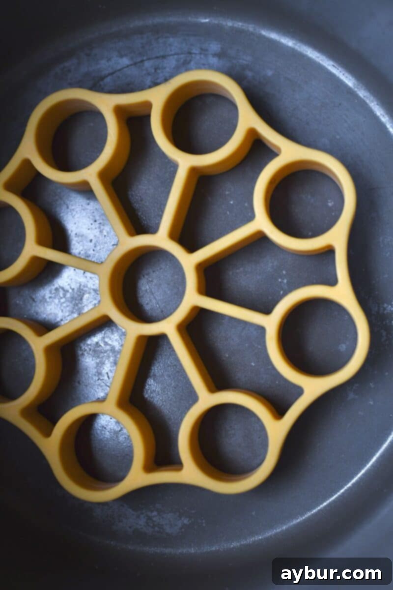 A silicone roasting rack meticulously placed at the bottom of an Instant Pot bowl, ready to support the brisket and prevent sticking.