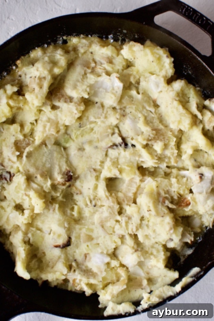Irish Colcannon Potatoes cooking for the second time in a cast-iron pan.