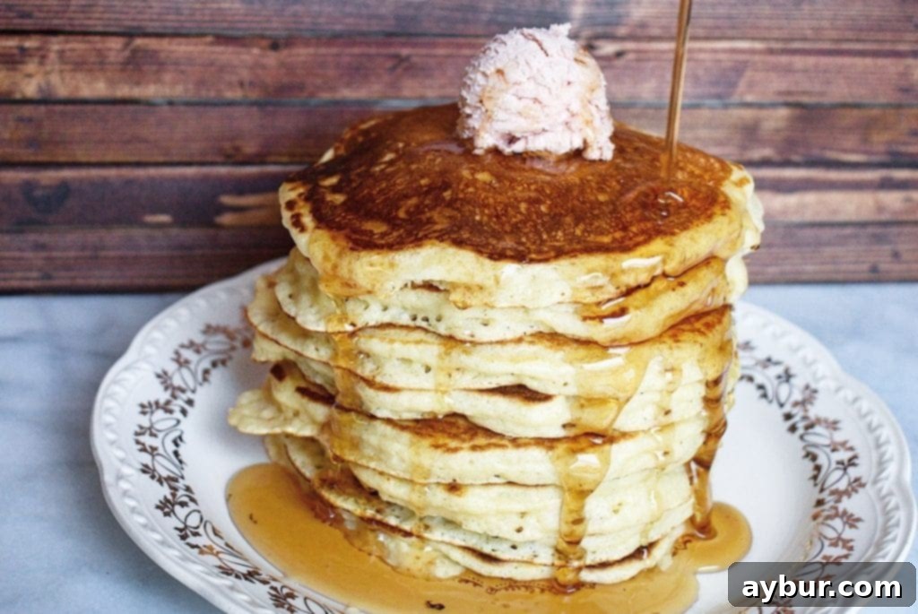 A close-up of a stack of fluffy pancakes, golden brown and perfectly cooked