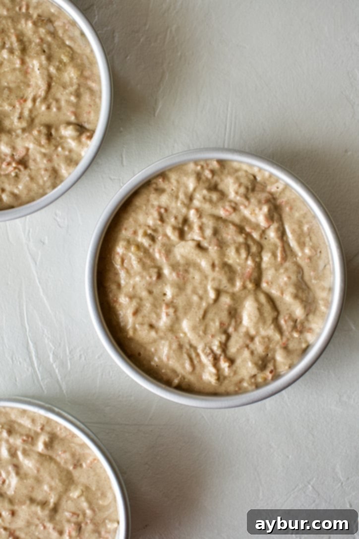 Uncooked Carrot Cake batter in prepared baking tins, ready for the oven.