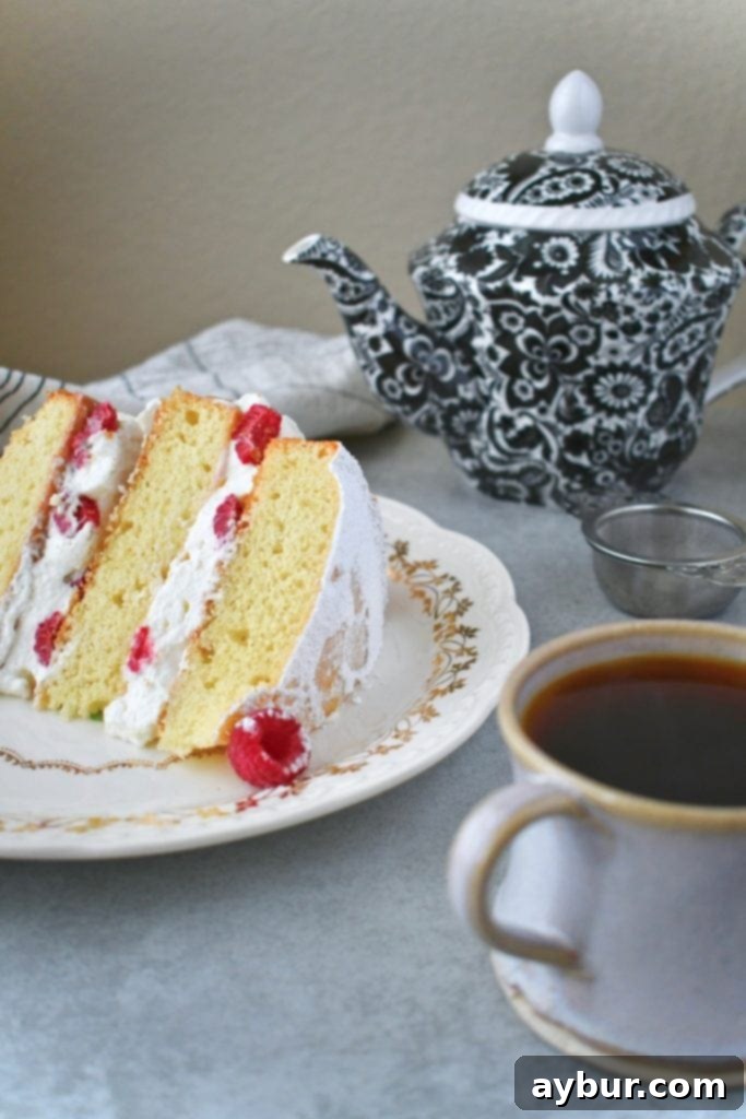 Traditional Victoria Sandwich cake with layers of sponge, cream, and homemade raspberry jam, served with Irish Breakfast Tea.
