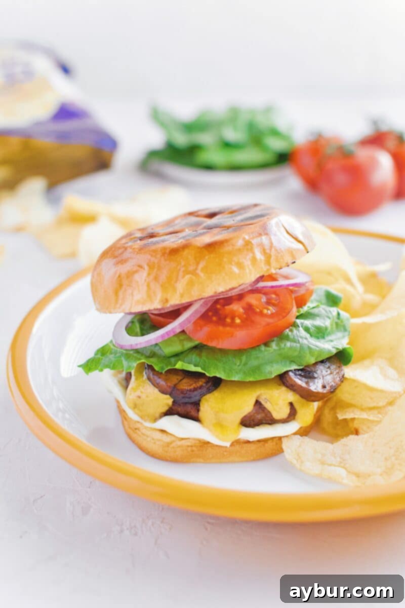 Not-So "Basic" Burger stacked up on a plate with chips and my favorite toppings.