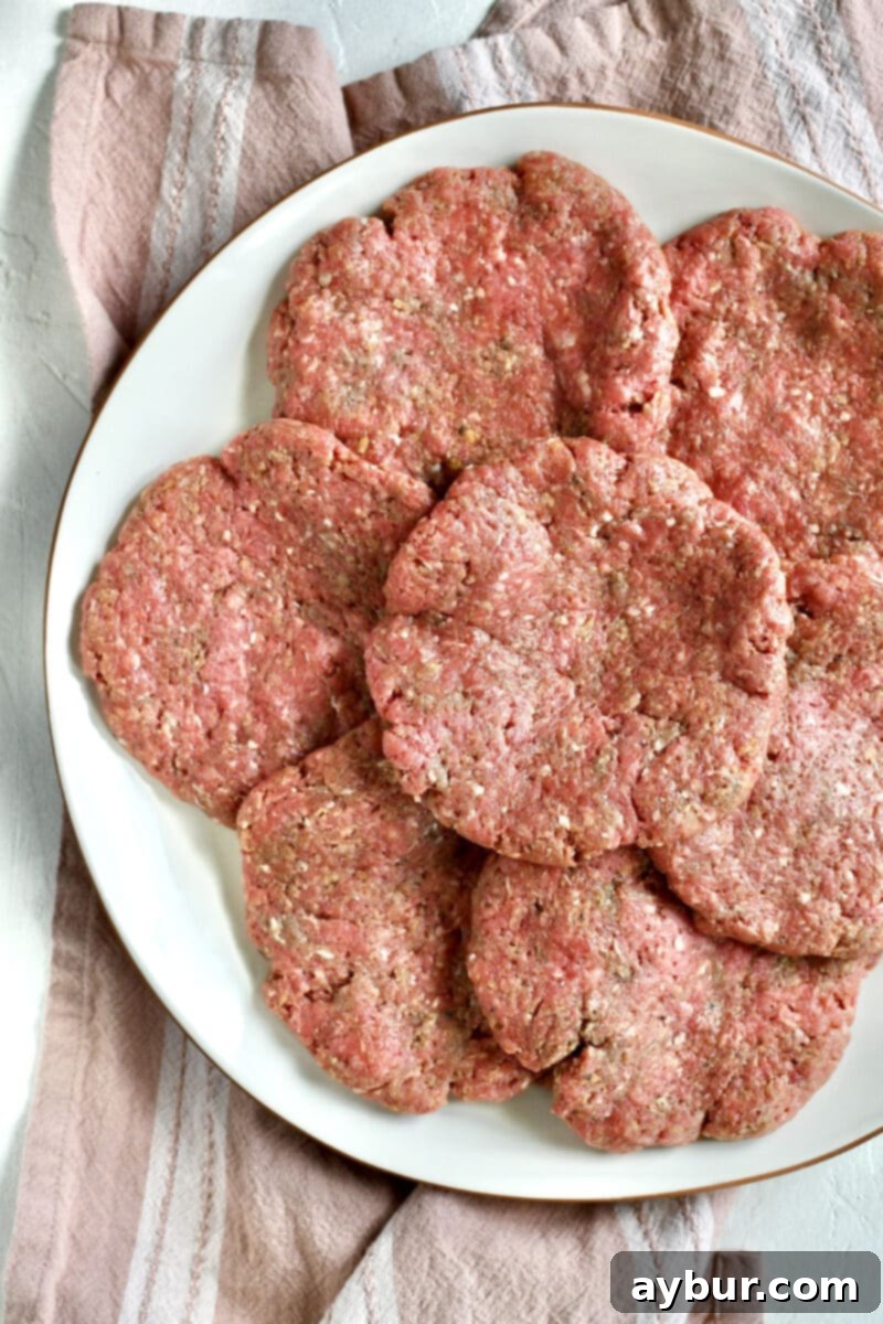 Pattied out burgers on a large platter.