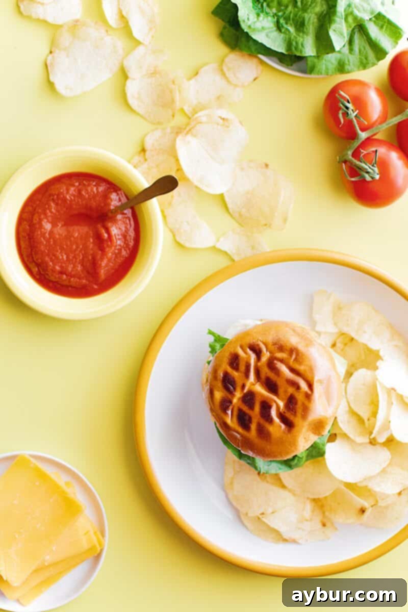 Not-So "Basic" Burger stacked up on a plate with chips and my favorite toppings.
