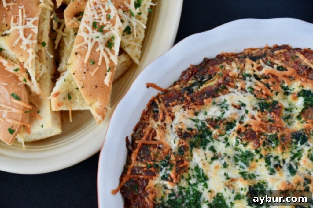A festive holiday table setting featuring the baked spinach and artichoke dip with garlic toast and other appetizers.