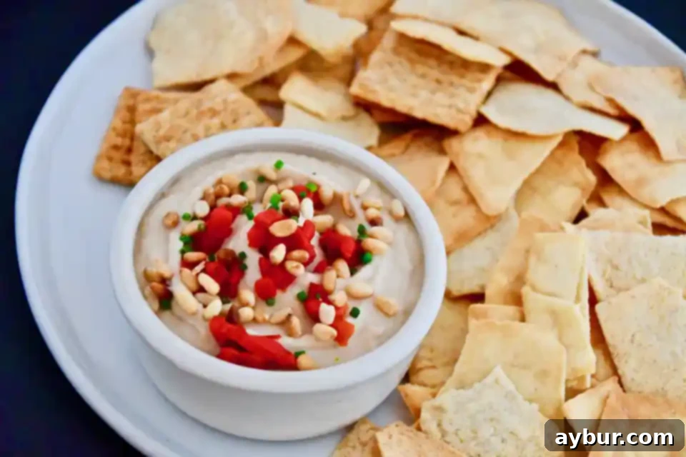 Bowl of white bean hummus with fresh pita bread and vegetables
