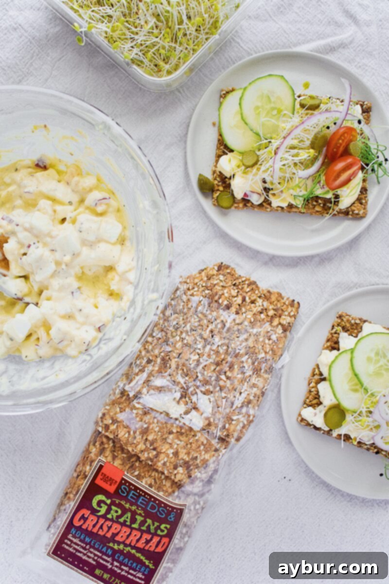 Scandinavian Dill Egg Salad 10 Nordic Egg Salad, beautifully plated on a slice of bread with fresh vegetables and sprouts.