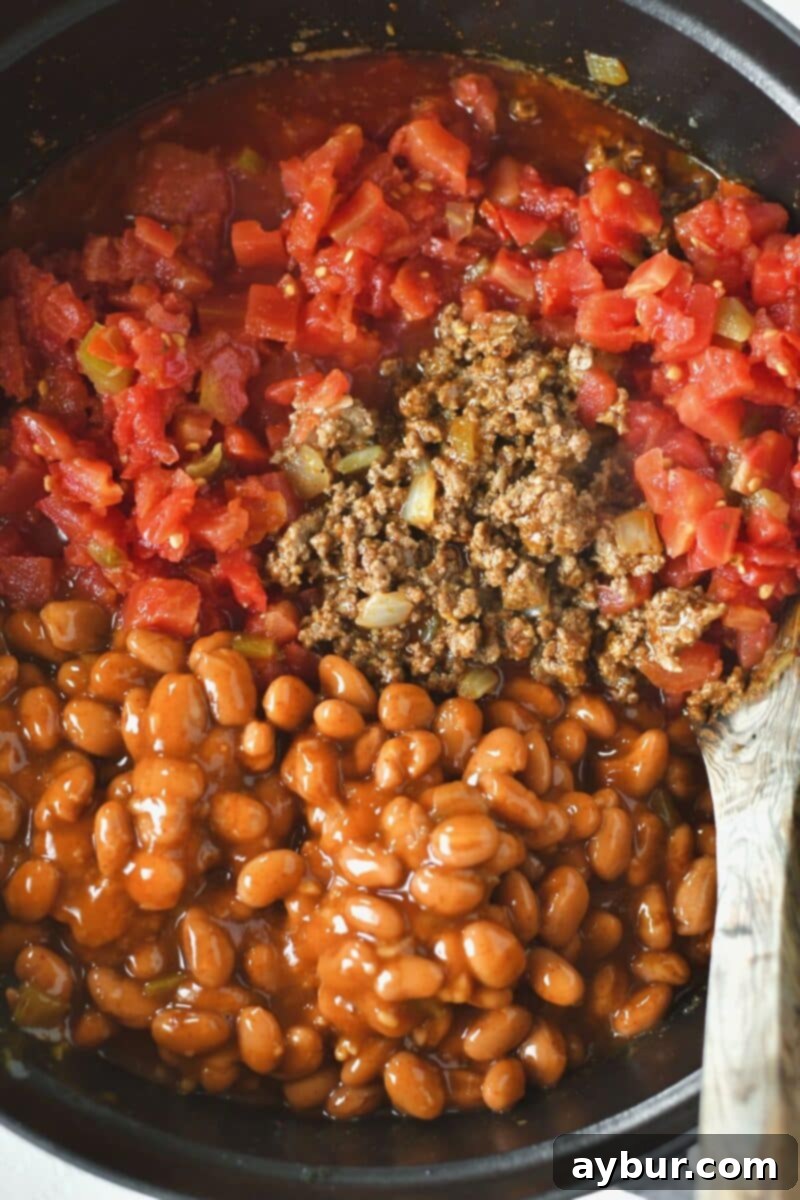 Wet ingredients and beans are added to the browned meat in a stock pot, ready for simmering.