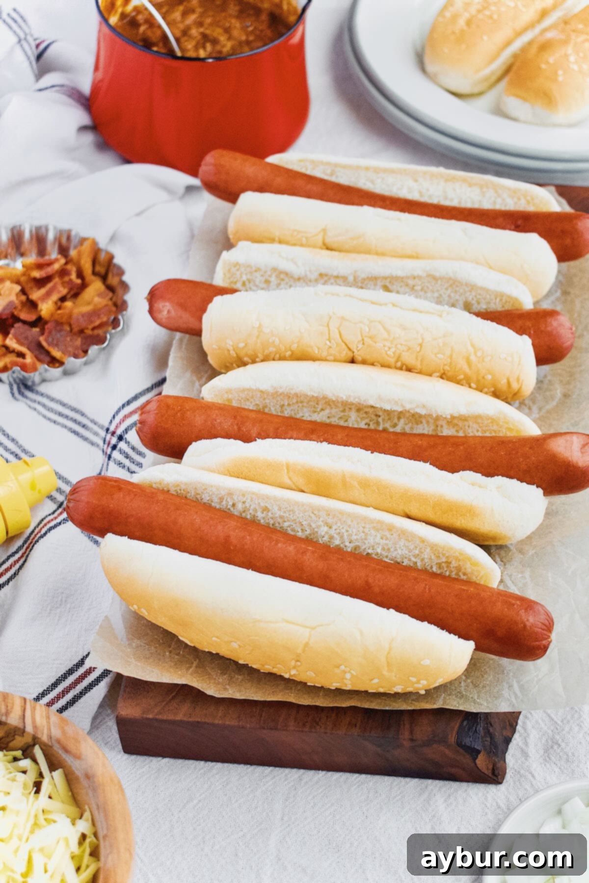 Perfectly steamed hot dogs arranged on a cutting board, ready for a variety of delicious toppings.