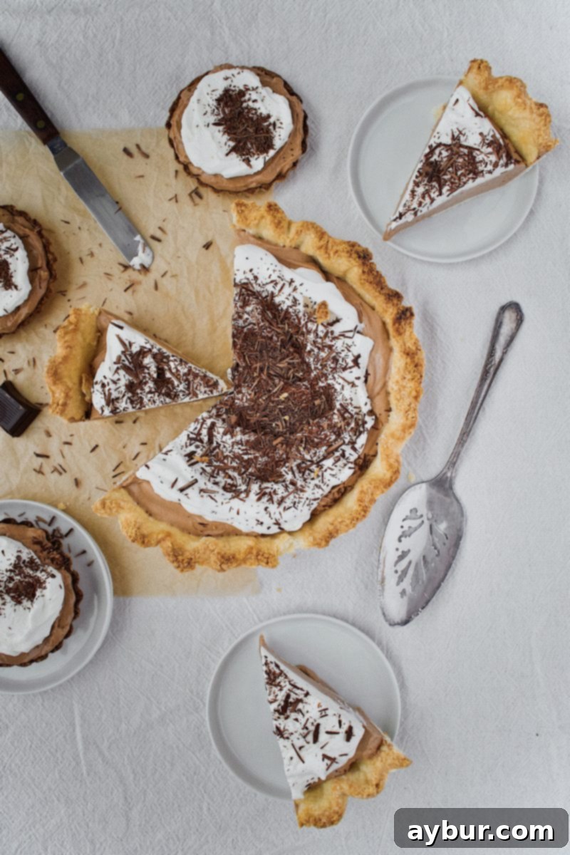 A beautifully presented slice of Joanna Gaines' French Silk Pie, featuring its layered textures and topped with a swirl of fresh whipped cream.