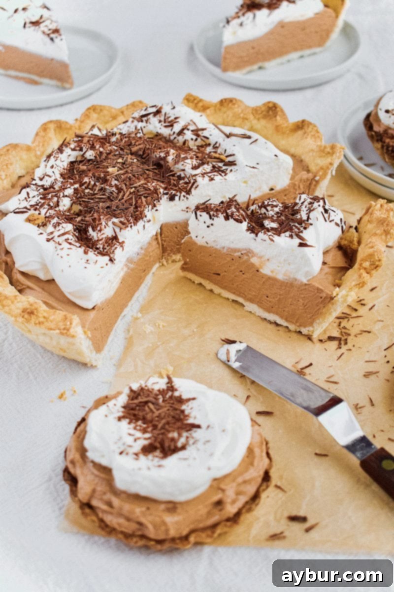 A final, enticing image of the French Silk Pie, perfectly sliced and ready to be served, alongside additional mini tartlets.