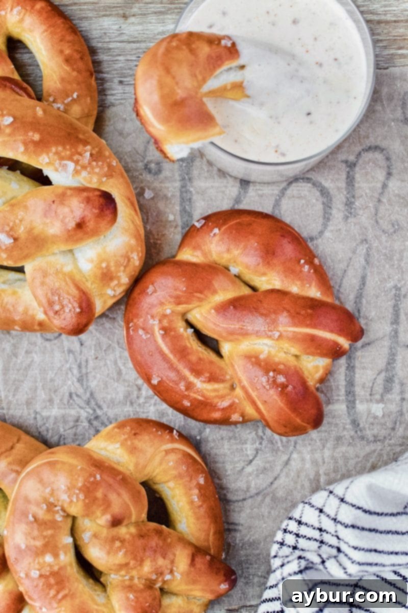 Authentic Movie Theater Pretzels and Cheese Dip 4 A close-up of warm, salted Joanna Gaines soft pretzels served with a rich, creamy cheese dip, perfect for a snack or party.