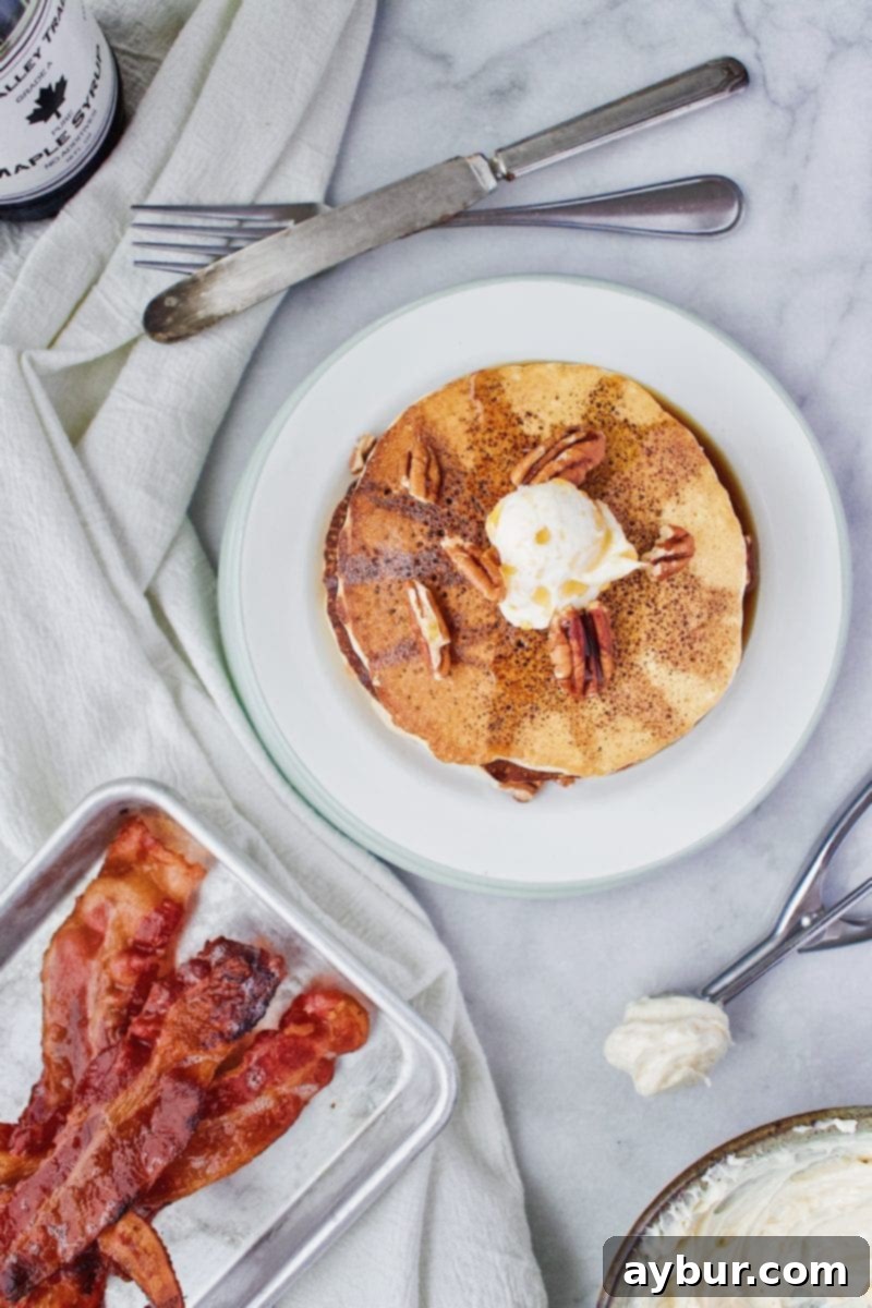 Close-up of fluffy Joanna Gaines Pecan Pancakes with a generous dollop of maple butter