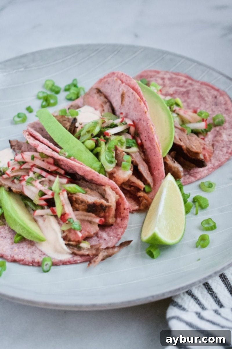 Joanna Gaines Steak Tacos, generously topped with a rich crema and a fresh, crunchy radish salad, presented on a homemade tortilla.