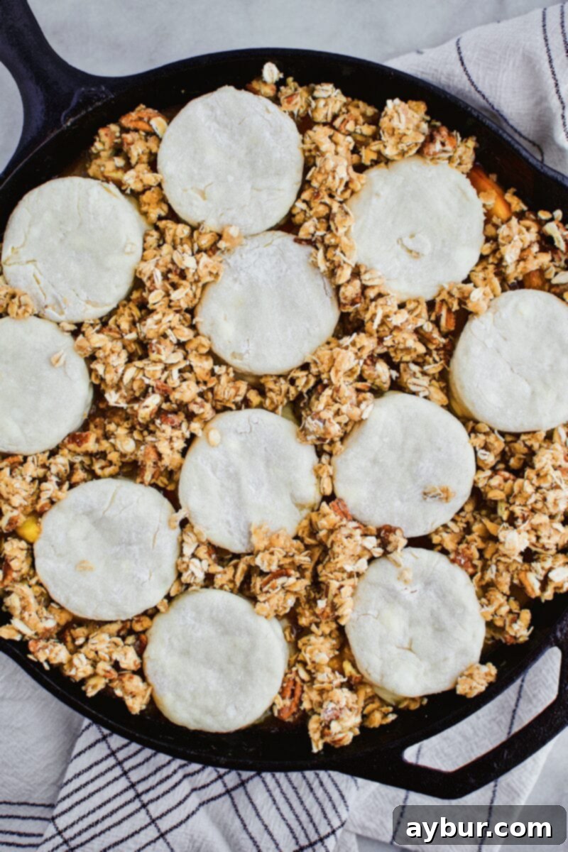 Rustic Skillet Peach Cobbler with Sweet Brown Sugar Crumble 6 Skillet Peach Cobbler assembly showing both homemade biscuits and the bourbon brown sugar crumble topping.