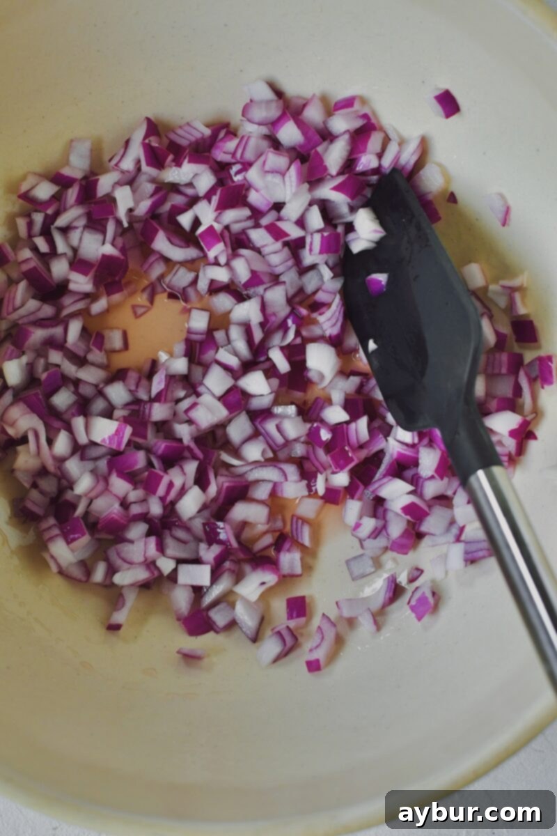 Vibrant Broccoli and Cauliflower Power Salad 5 Red Onions soaking in rosé vinegar for a quick pickle effect.