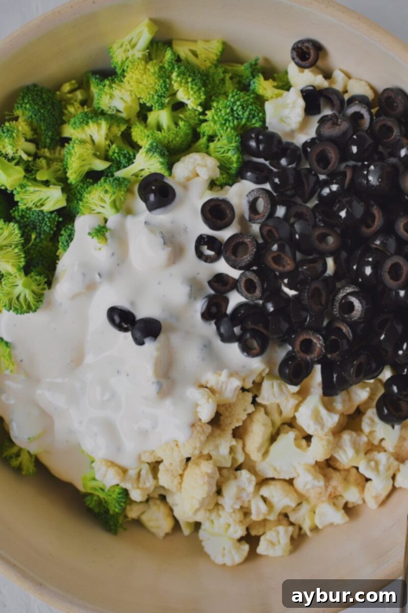 Vibrant Broccoli and Cauliflower Power Salad 6 Broccoli and cauliflower in a large bowl, adding the homemade ranch dressing and black olives to it.