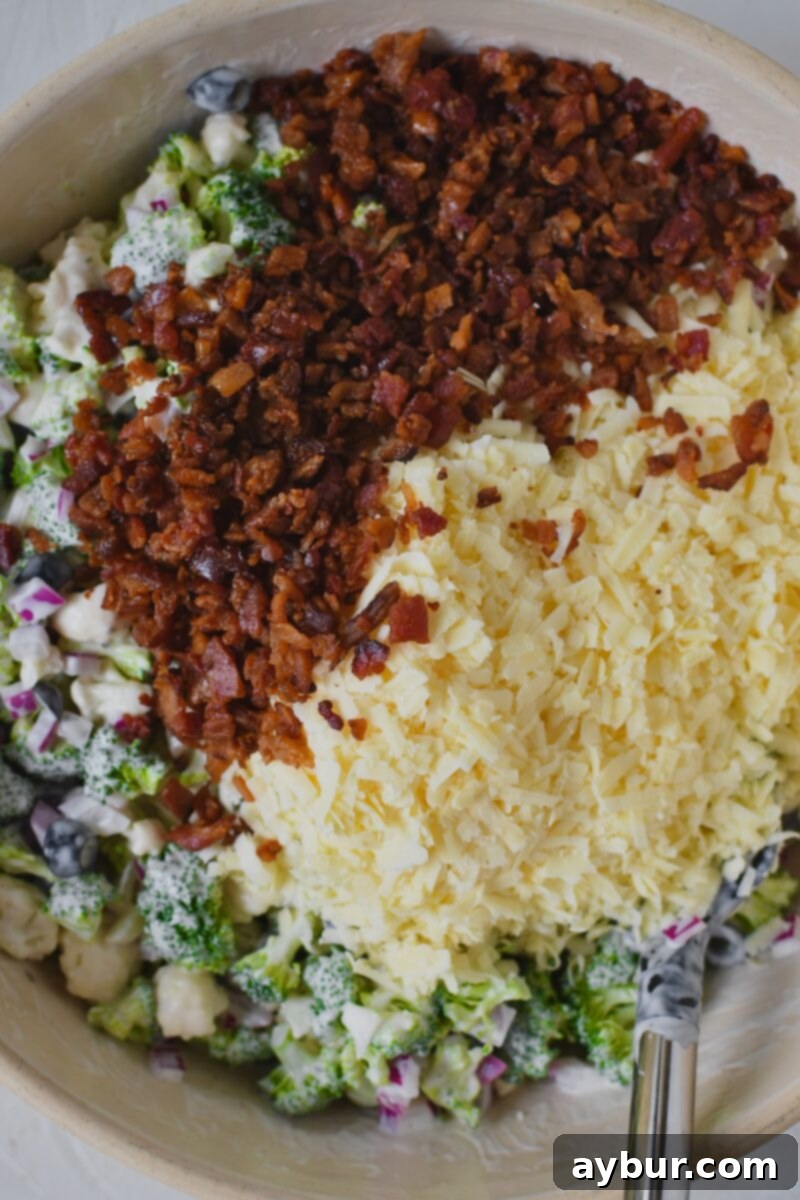 Vibrant Broccoli and Cauliflower Power Salad 7 After mixing in the olive and ranch, adding in the cheese and bacon.