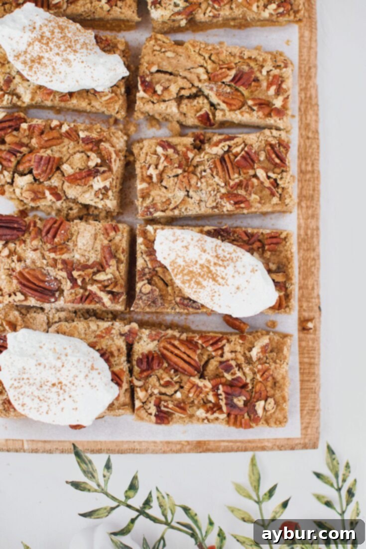 Spiced Pumpkin Bars 7 Pumpkin Dessert Bars, cut into squares and topped with whipped cream, ready for serving.