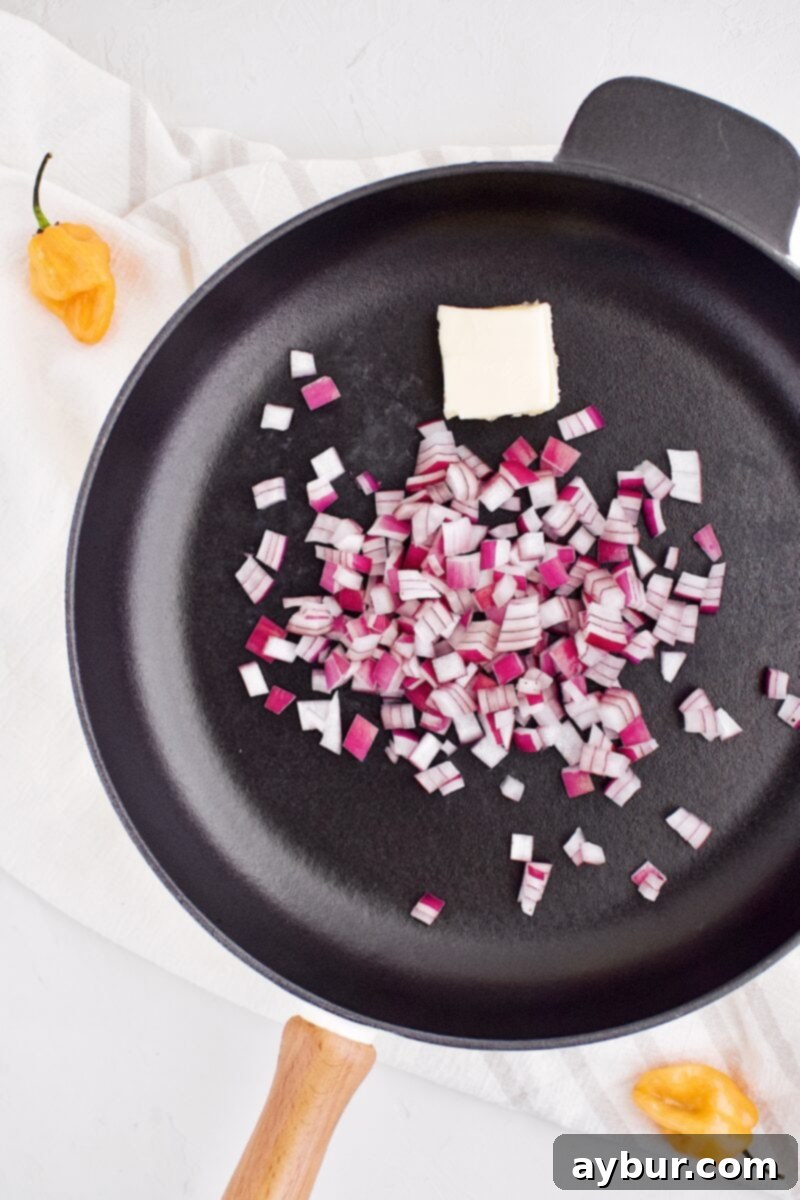 Butter melting in a pan with diced red onions, ready to be sautéed