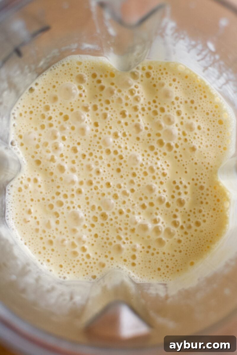 Overhead image of golden cheddar syrup in a blender.