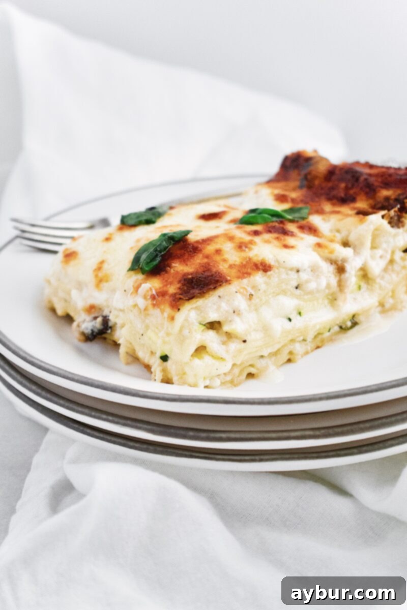 Freshly baked Joanna Gaines White Vegetable Lasagna, hot out of the oven, with bubbling cheese and visible vegetable layers.