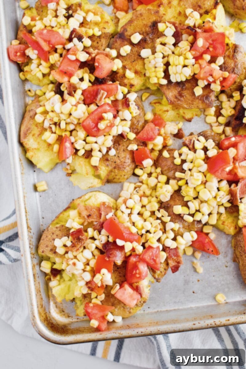 Smashed potatoes topped with a colorful corn salad, ready for final broiling