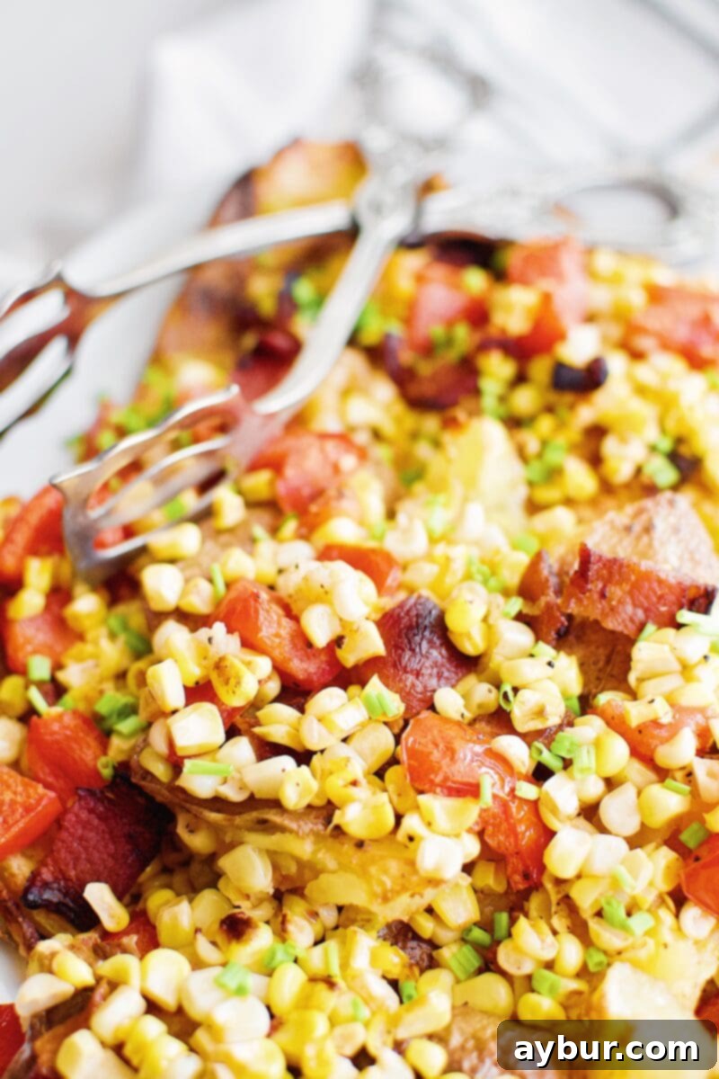 Smashed Potatoes with Corn, Tomato, and Bacon Salad served as a gourmet side dish