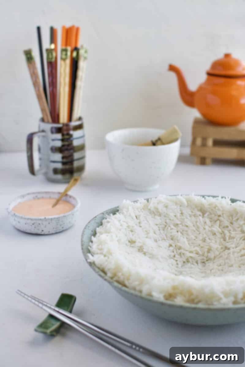 Seasoned sushi rice spread out on a plate, cooling to room temperature.