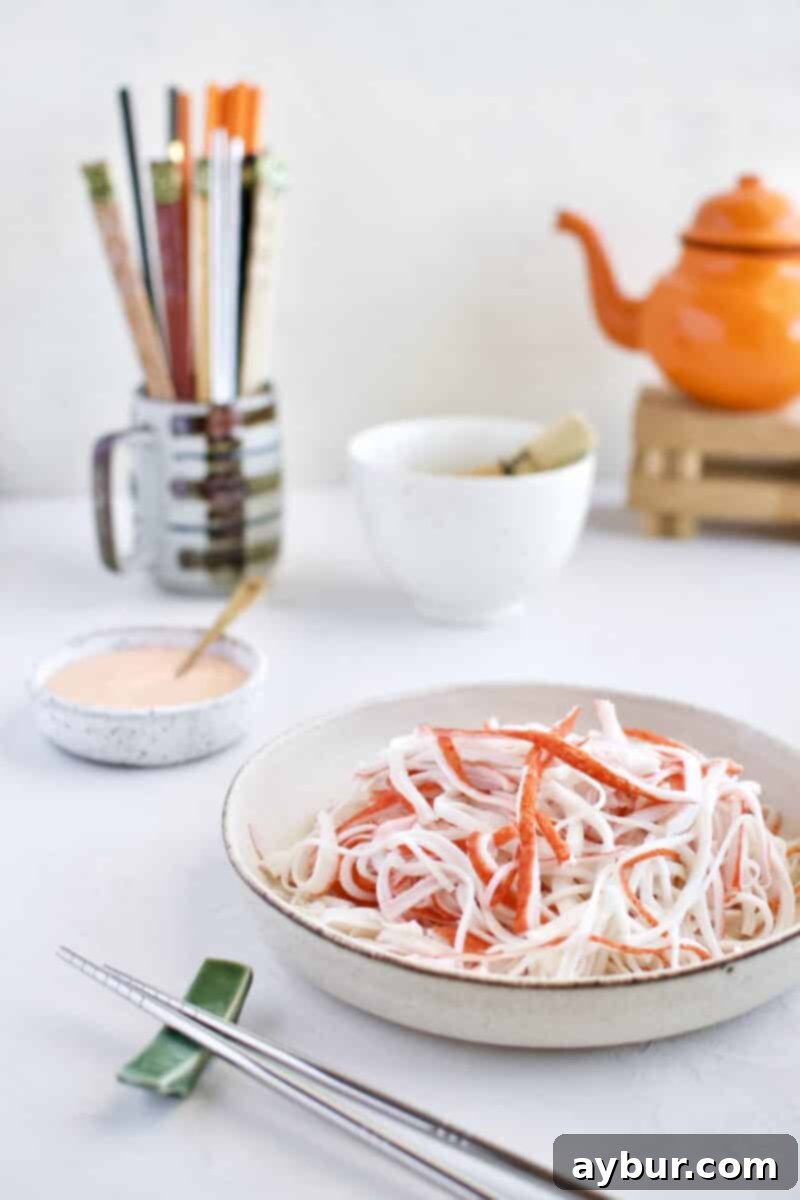 Shredded imitation crab sticks, prepared for the Ahi Tuna Tower recipe, showcasing their delicate ribbon-like texture.