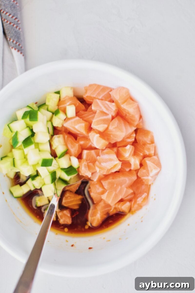 Diced salmon, cucumber, and poke marinade combined in a bowl, offering an alternative to tuna.