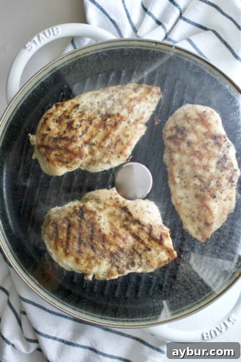 grill with lid on and chicken steaming inside