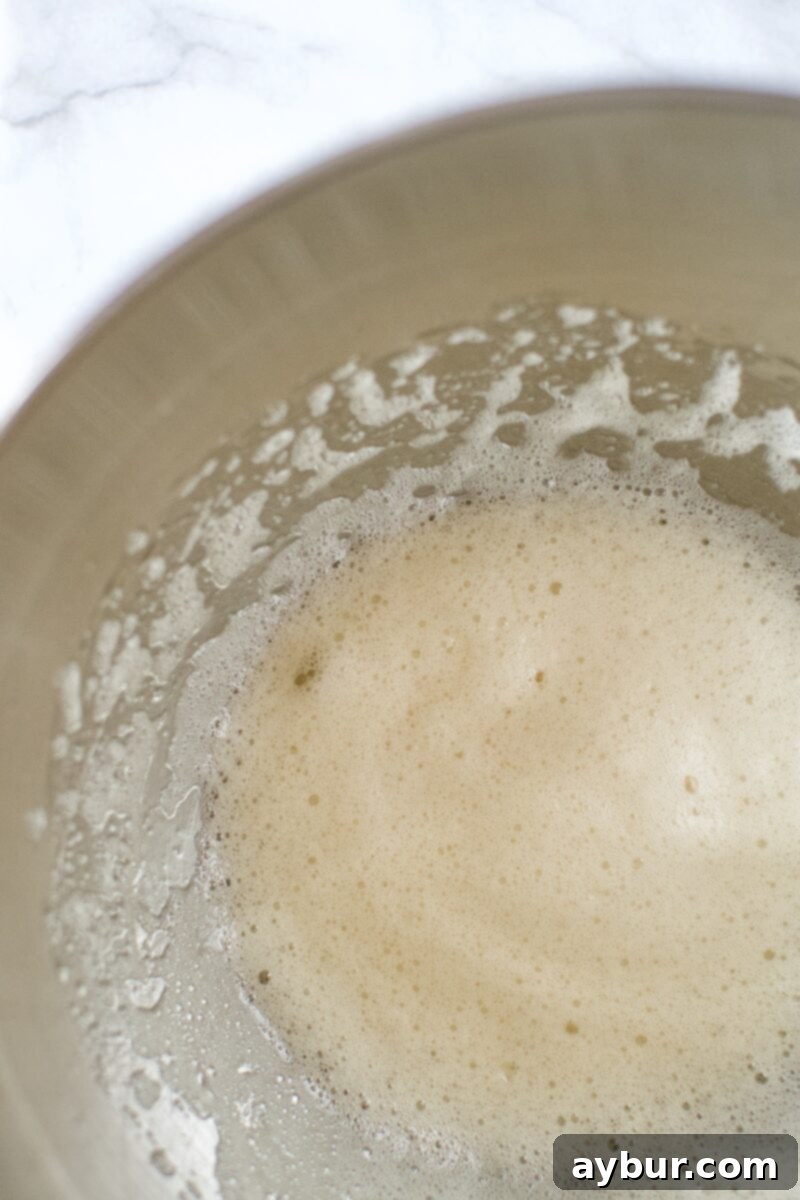 Harvest Pumpkin Spice Pecan Pralines 4 A bowl containing frothy whipped egg whites, water, and vanilla extract.