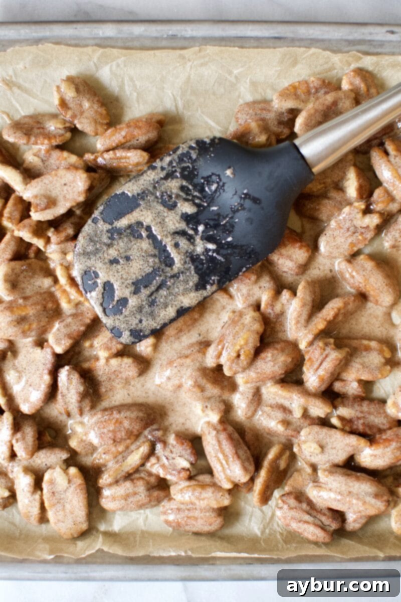 Harvest Pumpkin Spice Pecan Pralines 7 Seasoned pecan halves spread in a single layer on a parchment-lined baking sheet, ready for the oven.