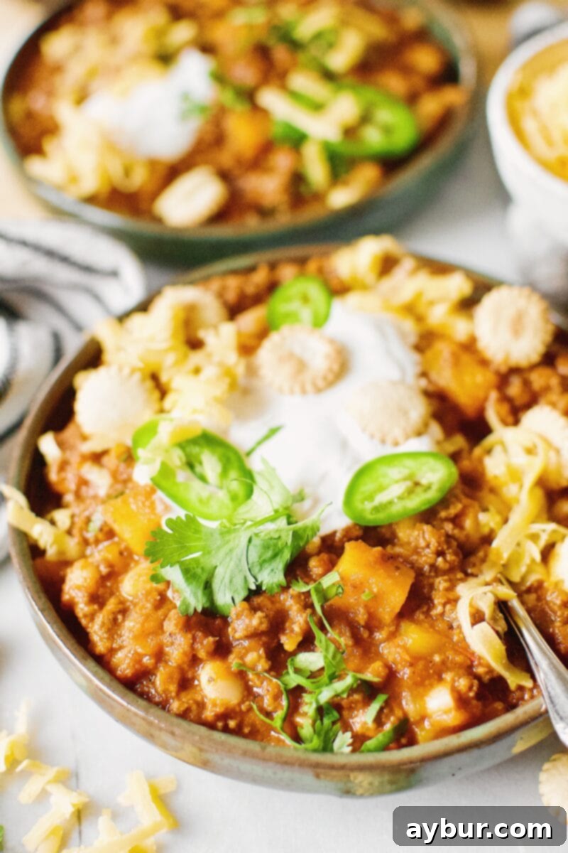 Harvest Pumpkin Chili 4 Two bowls of Pumpkin Chili garnished with oyster crackers, cilantro, jalapeno and cheese.