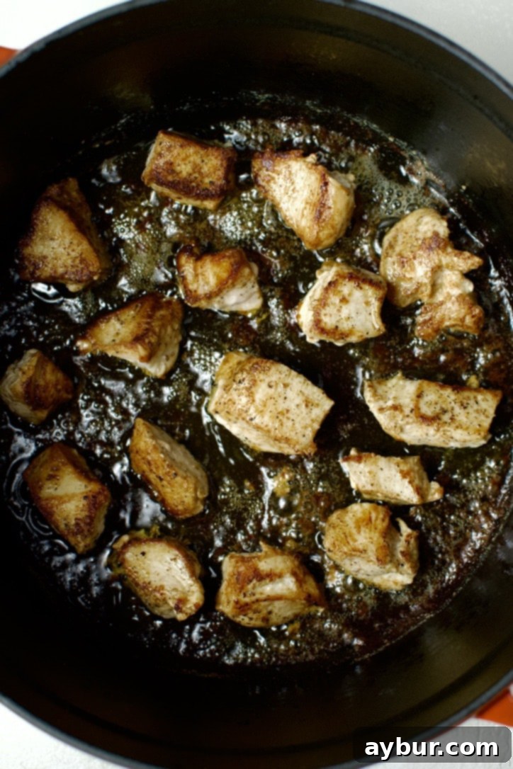 Chicken searing in the bottom of a dutch oven.