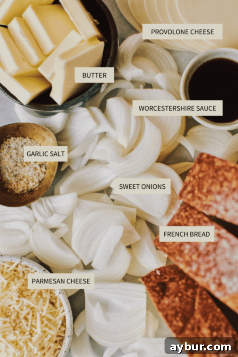 Various fresh ingredients laid out for French Onion Soup, including thinly sliced sweet onions, a stick of butter, a block of cheese, and a fresh loaf of French bread.