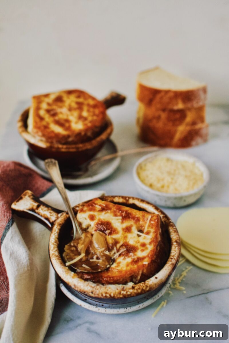 French Onion Soup served in a classic brown crock, with appetizing steam rising from the melted, browned cheese and golden bread, ready to be enjoyed.