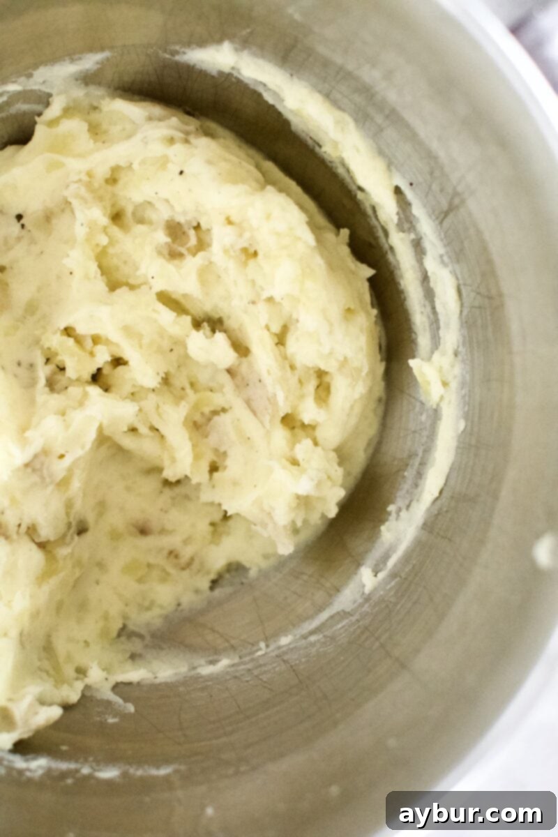 Loaded Baked Potato Mash 5 Potatoes after being whipped with butter, salt, and pepper, showing a smooth, creamy texture.