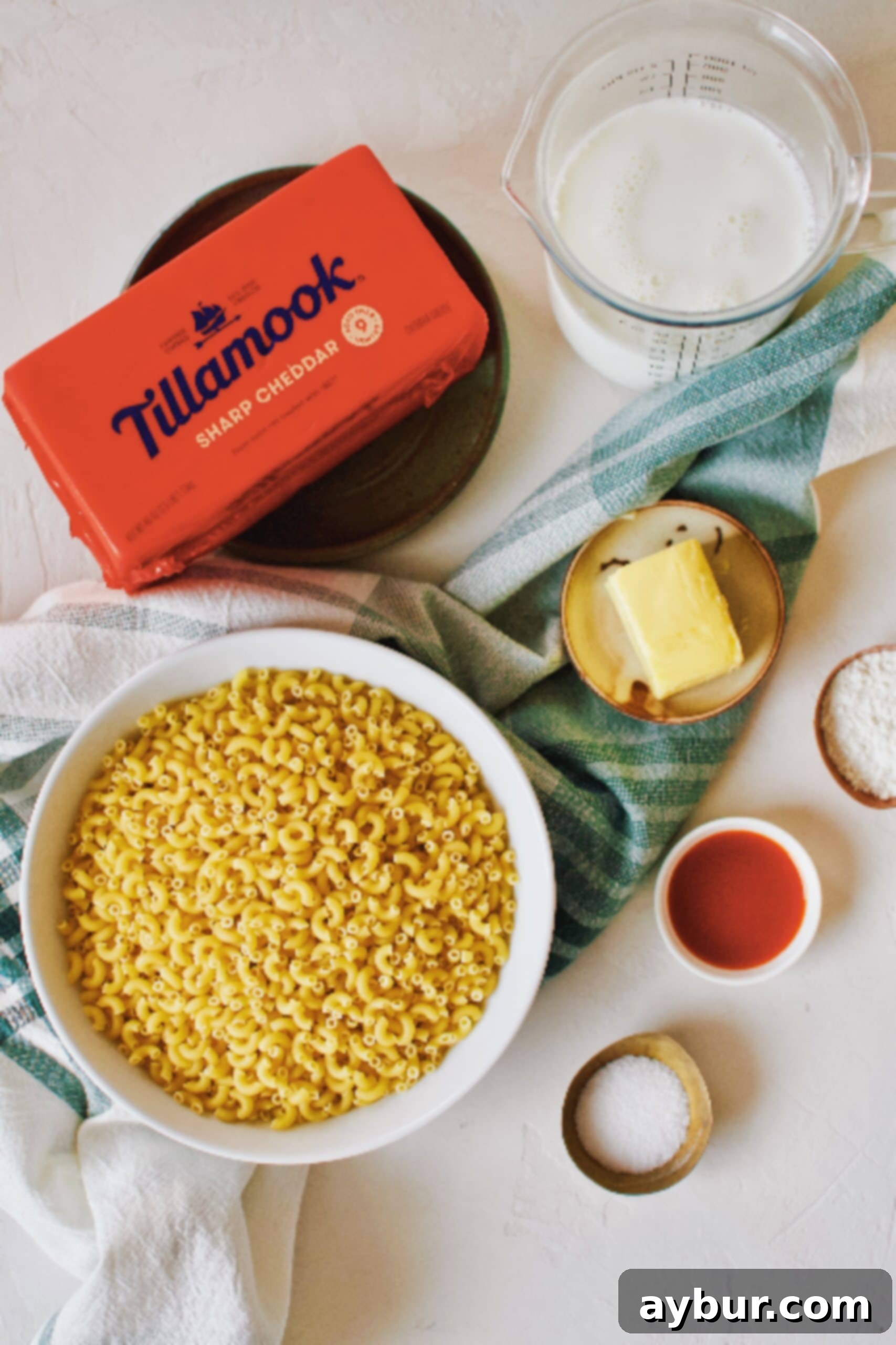 Velvety Golden Cheddar Sauce 4 A flat lay of fresh ingredients laid out on a kitchen counter, including butter, flour, milk, and a block of high-quality cheddar cheese, all essential for making Cheddar Syrup.